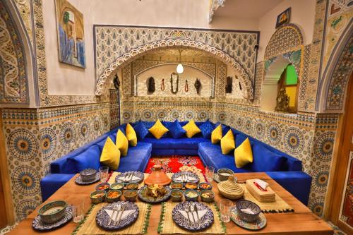Sofá azul en una habitación con mesa en Riad Moroccan Style en Fez