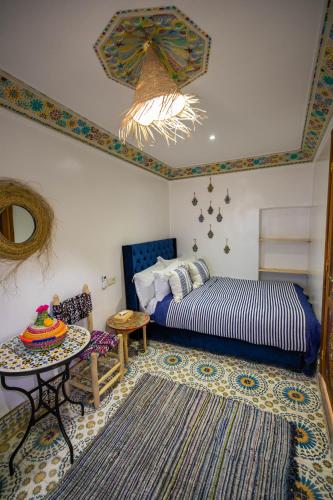 a bedroom with a bed and a table and a rug at Riad Moroccan Style in Fez