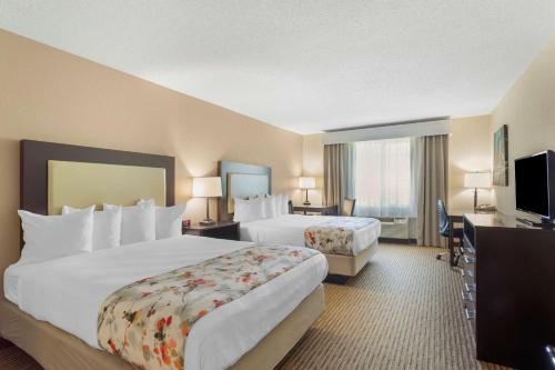 a hotel room with two beds and a flat screen tv at Best Western Lawrenceburg Inn in Lawrenceburg