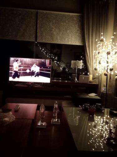 a living room with a tv and a table with lights at Lia Luxury home 2ΥΔ 110 τ μ in Chrysoupolis
