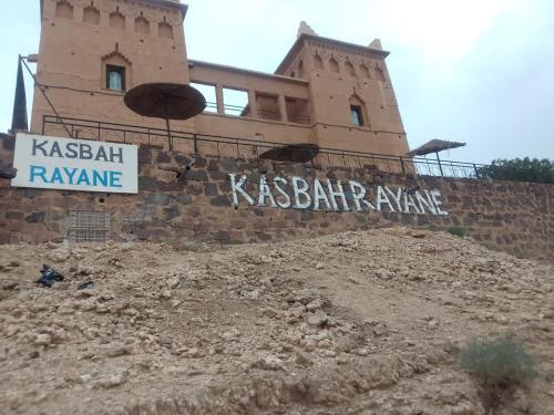 a building on a hill with a sign on it at Kasbah Rayane Ait Ben Haddou in Aït Ben Haddou