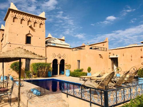 a courtyard with chairs and a swimming pool in a building at Kasbah Rayane Ait Ben Haddou in Aït Ben Haddou
