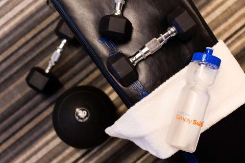 a bottle of water in a suitcase with a towel at Sonesta Simply Suites Chicago Waukegan in Waukegan