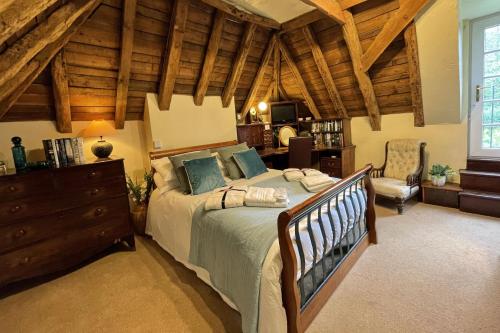 1 dormitorio con 1 cama grande y techo de madera en The Coach House by Bloom Stays, en Harrietsham
