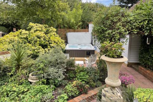 a garden with a grill and some plants and flowers at The Coach House by Bloom Stays in Harrietsham
