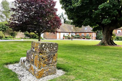 a stone pillar in the middle of a field with a tree at The Coach House by Bloom Stays in Harrietsham