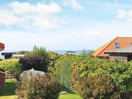 a view of a yard with bushes and a house at 4 person holiday home in Assens in Assens