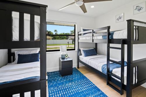 een slaapkamer met een stapelbed en een blauw tapijt bij Villa Paradise Miami, Luxury Gem with Heated Pool, Game Room, Fire Pit, 3 Bed 2 Bath in Miami