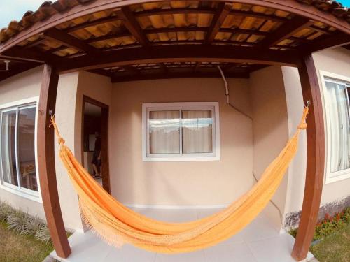 a hammock on the outside of a house at Vila do Rosa in Praia do Rosa