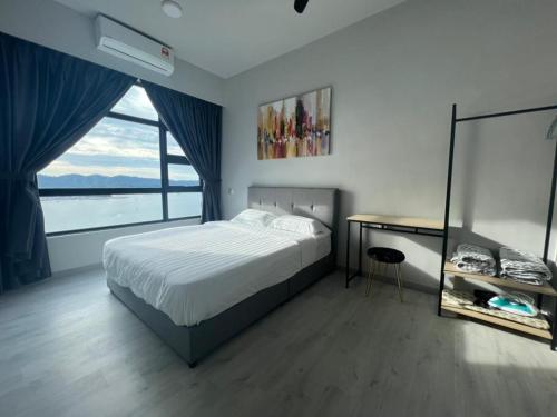 a bedroom with a bed and a desk and a window at Jesselton Quay Seaview Homestay with free 1 parking by StayPlace in Kota Kinabalu