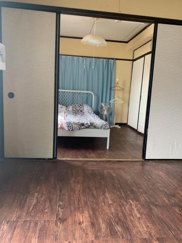 1 dormitorio con 1 cama a través de una puerta corredera de cristal en 山下ホテル305, en Kurosakimachi
