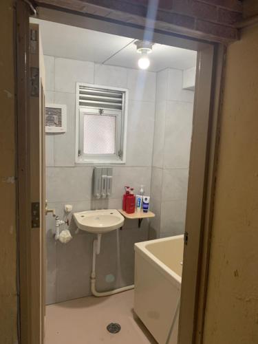 a bathroom with a sink and a bath tub at 山下ホテル305 in Kurosakimachi