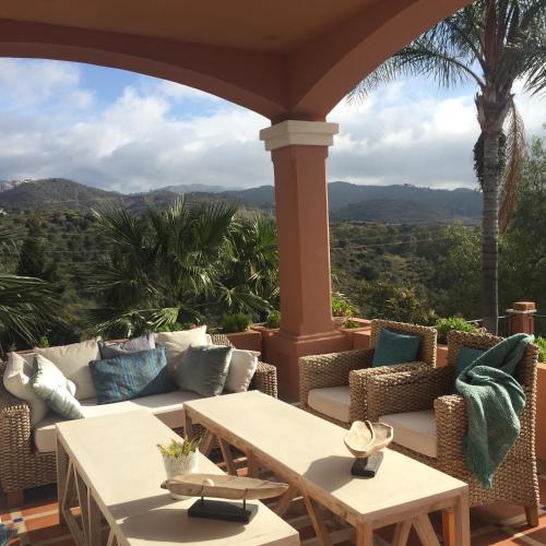 a patio with couches and tables and palm trees at The Marbella Heights Boutique Hotel in Marbella