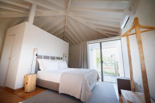1 dormitorio con cama y ventana grande en Vila Marim Country Houses, en Mesão Frio