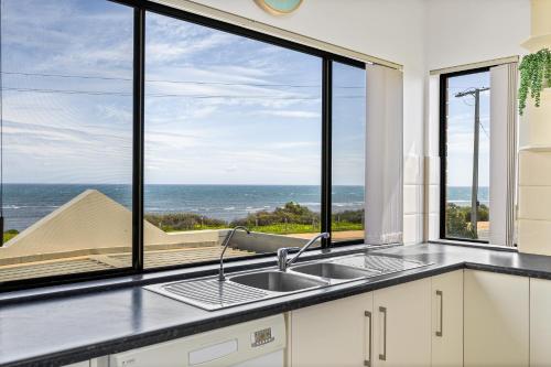 a kitchen with a sink and a view of the ocean at Mareblue Villa - Aldinga Beach - C21 SouthCoast Holidays in Aldinga Beach