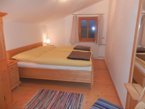 a bedroom with a bed and a window at Ferienwohnung Örgenbauer in Saalfelden am Steinernen Meer