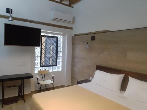 a bedroom with a bed and a desk and a window at Hotel Sonno Plaza Allende in Mexico City