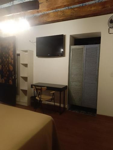 a room with a table and a tv on the wall at Hotel Sonno Plaza Allende in Mexico City