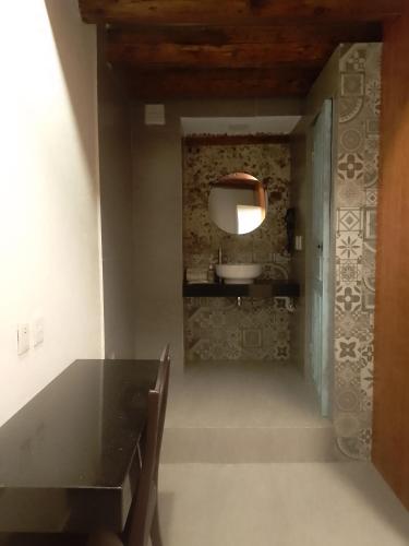 a dining room with a black table and a mirror at Hotel Sonno Plaza Allende in Mexico City
