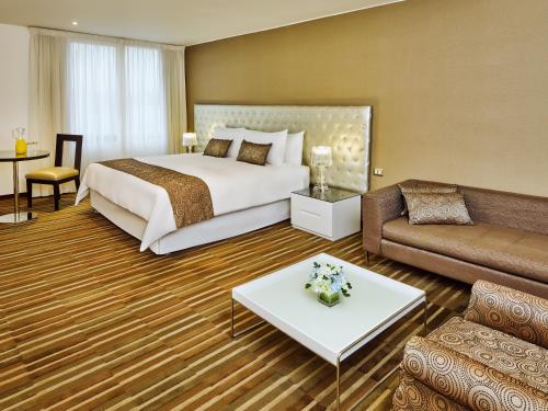 una camera d'albergo con letto e divano di NM Lima Hotel a Lima