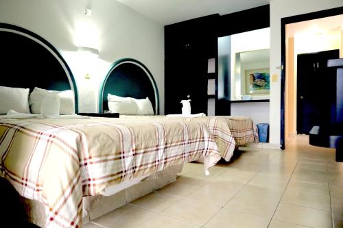a bedroom with two beds and a large mirror at HC International by R&T in Cancún