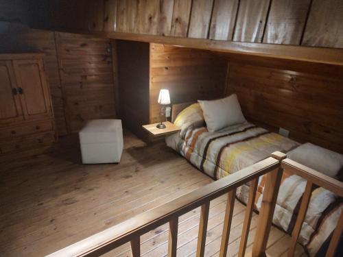 ein Schlafzimmer mit einem Bett in einer Holzhütte in der Unterkunft El Rincón de Cata in Tandil