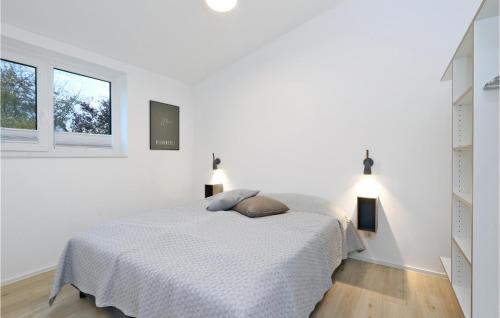 a white bedroom with a bed and two windows at Beach Front Home In Lembruch-dmmer See With Wifi in Lembruch