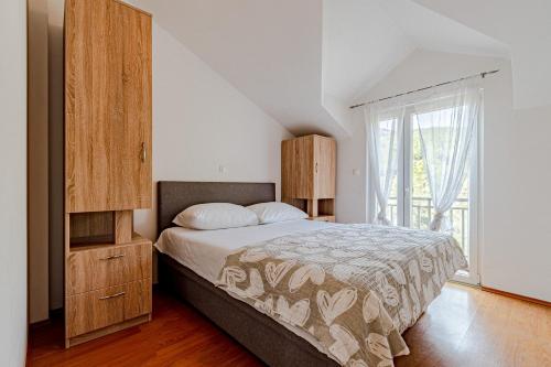 een slaapkamer met een bed en een groot raam bij Apartments by the sea Cove Poplat, Korcula - 20023 in Vela Luka