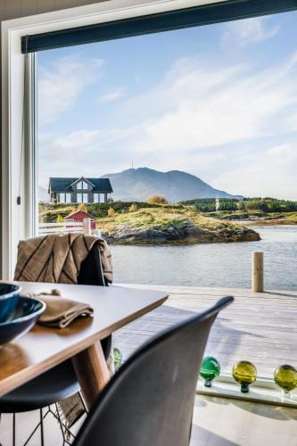 a room with a table and chairs and a large window at Rorsundet Brygge in Vega