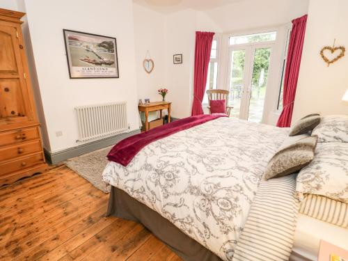 a bedroom with a bed and a window at Hafan Y Mor in Rhos-on-Sea