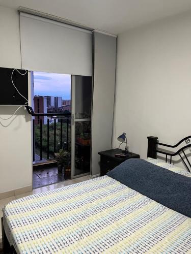 a bedroom with a bed and a large window at APARTAMENTO CONDINA PEREIRA in Pereira