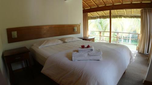 une chambre avec un lit avec des serviettes dessus dans l'établissement La Casa de Pitty, à Máncora