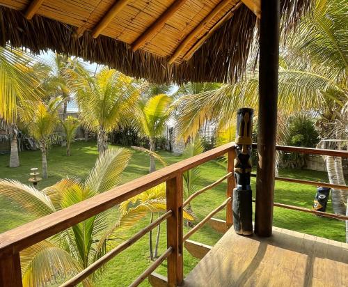 a balcony with a view of a yard with palm trees at La Casa de Pitty in Máncora