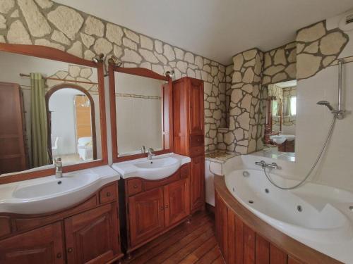 La salle de bains est pourvue de 2 lavabos et d'une baignoire. dans l'établissement Cottage, Hillion, à Hillion