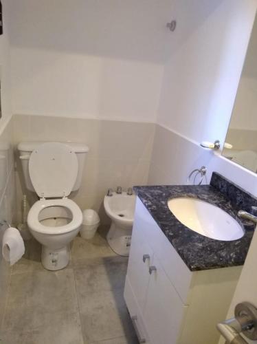 ein weißes Bad mit einem WC und einem Waschbecken in der Unterkunft Alquiler DIARIO hasta 4 personas in Tandil