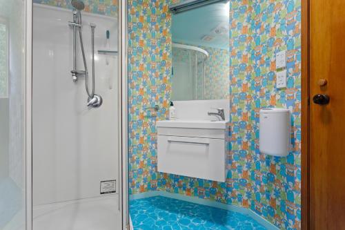 W łazience znajduje się umywalka i prysznic. w obiekcie Garden House w mieście Opotiki