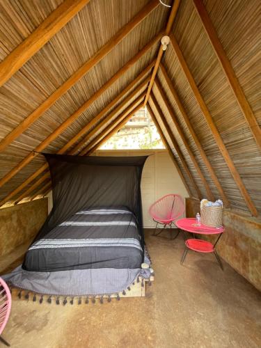 - un lit dans une tente avec une table et des chaises dans l'établissement Casa Xadani, à Cerro Largo