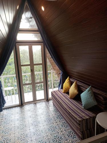 a room with a couch and a large window at Porsu in Canacona