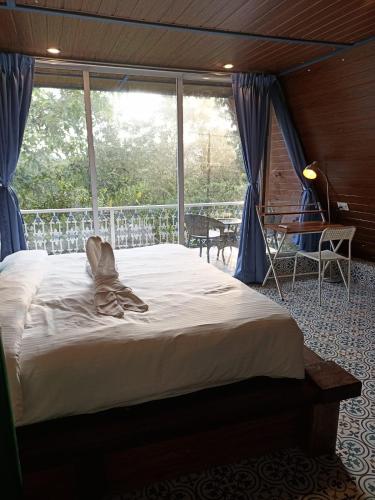 a bed in a room with a large window at Porsu in Canacona