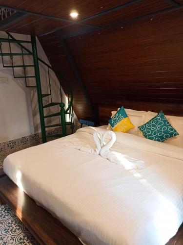two beds in a room with white towels on them at Porsu in Canacona