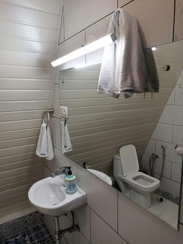 a white bathroom with a sink and a toilet at Porsu in Canacona