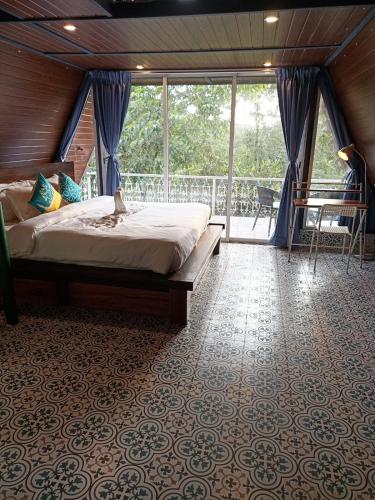 a bedroom with a bed and a balcony at Porsu in Canacona