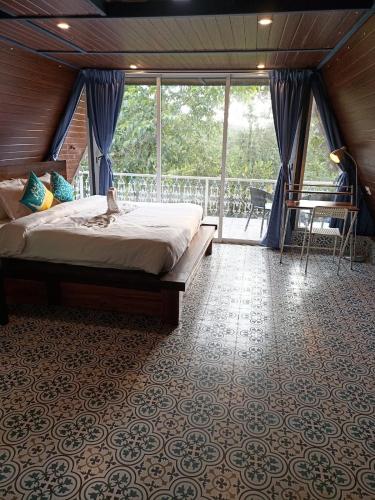 a bedroom with a bed and a balcony at Porsu in Canacona