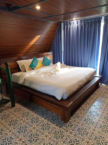 a bedroom with a large bed with a wooden headboard at Porsu in Canacona