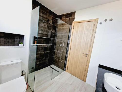 a bathroom with a shower with a glass door at Apartamento encantador com piscina e vista mar in Praia