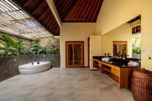 a bathroom with a bath tub and a sink at 5 BR Villa Sultan Luxury Entertainment and Relaxation in Seminyak