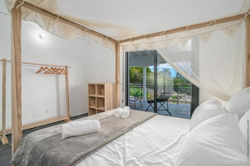 a bedroom with a large bed and a balcony at VILLA 55°AOC in Grande Anse