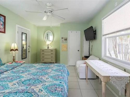 um quarto com uma cama, uma mesa e uma janela em Charming Studio Unit Across from Lido Key Beach em Sarasota