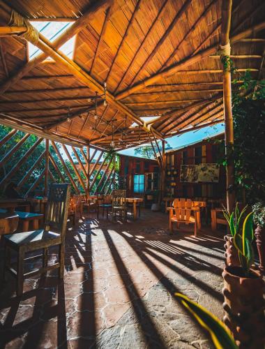 a patio with tables and chairs under a wooden roof at Lush Atitlán in San Marcos La Laguna