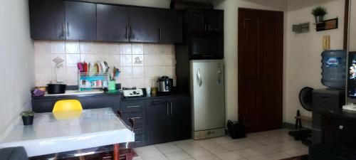 a kitchen with black cabinets and a stainless steel refrigerator at Mediterania palace residences kemayoran in Jakarta